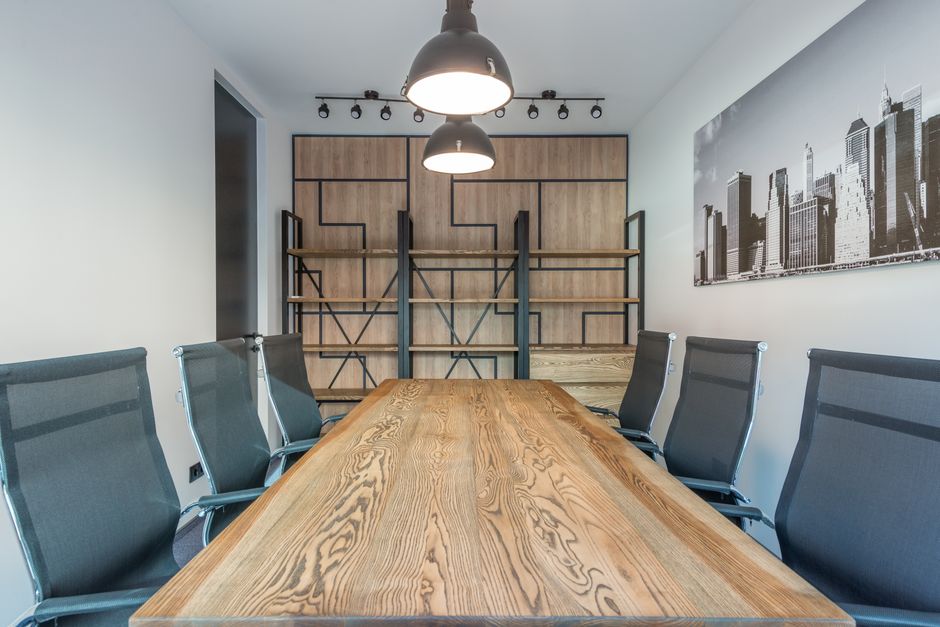 Contemporary workspace interior with armchairs and desk under lamps against photography of city in office
