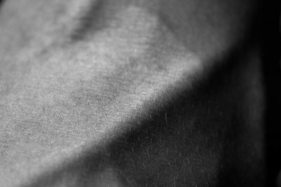 Close-up black and white image showcasing the fine texture and details of fabric under soft lighting.