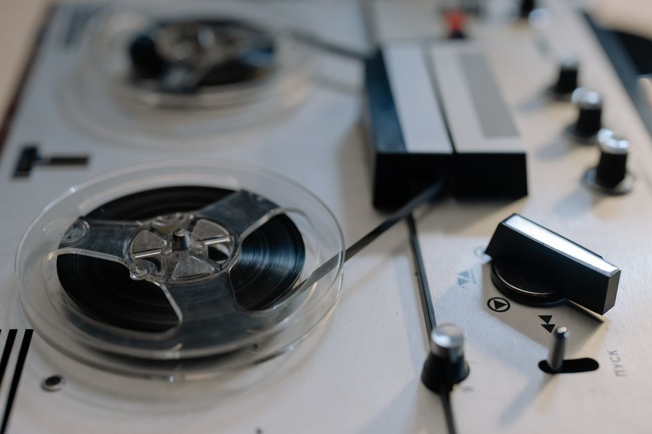 Close-up view of a classic reel-to-reel tape recorder with knobs and tapes.