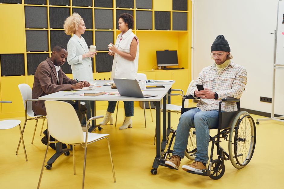 A diverse office team collaborating indoors, showcasing teamwork and inclusivity.