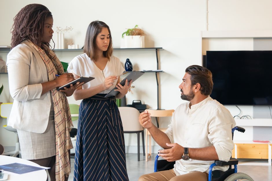 Three coworkers in a contemporary office having a discussion, fostering teamwork and inclusion.