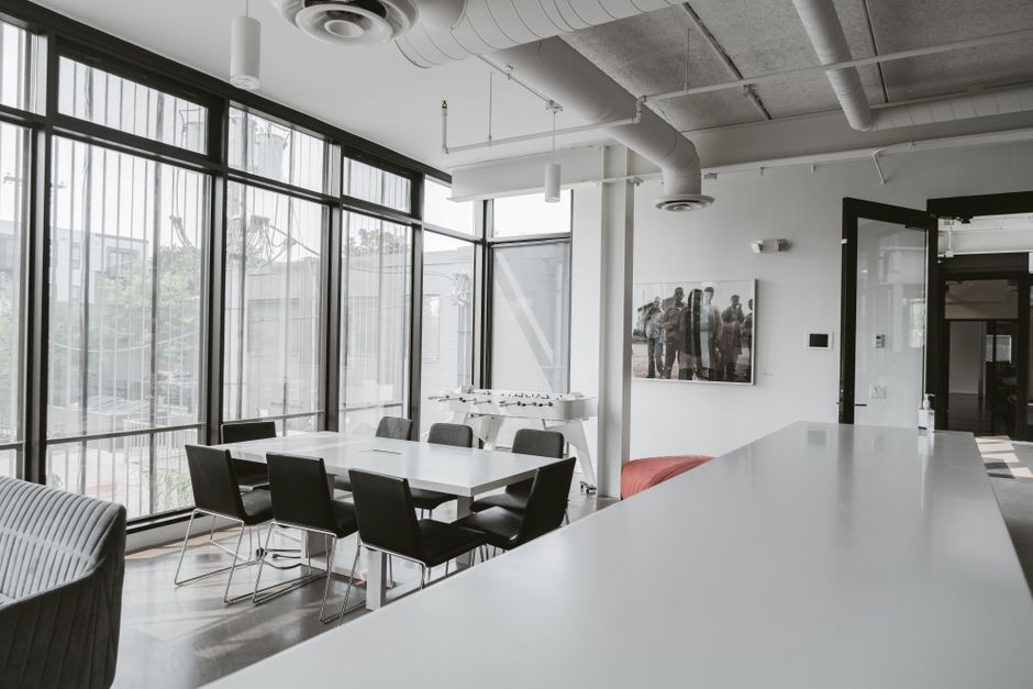 Bright and airy modern office space featuring a large conference table and sleek design elements.