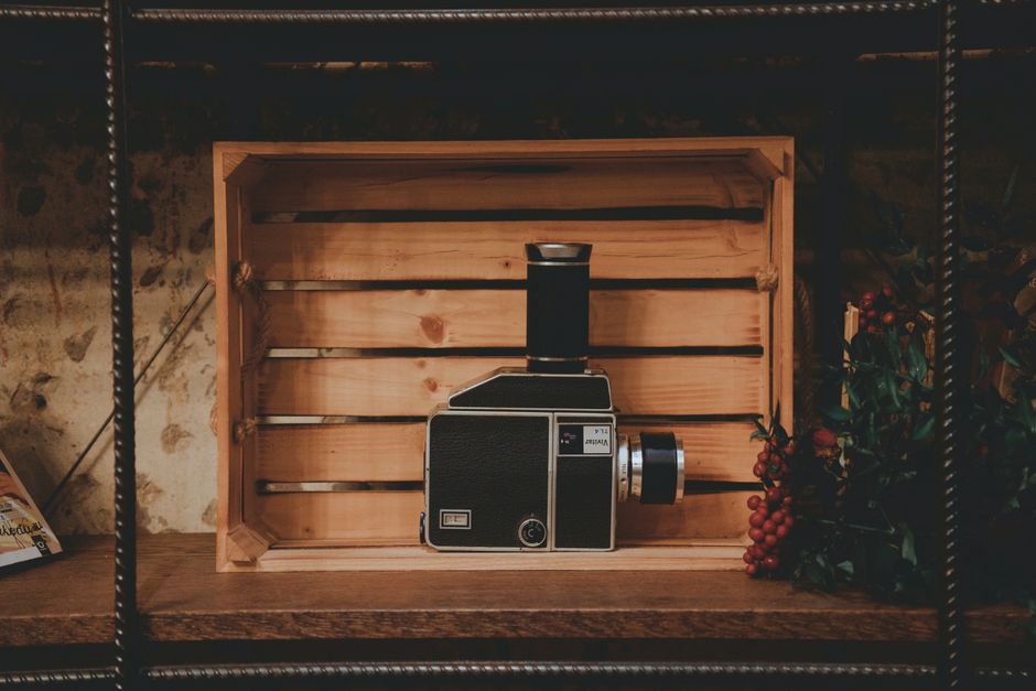 Stylish vintage camera displayed in a wooden crate creating a retro aesthetic.