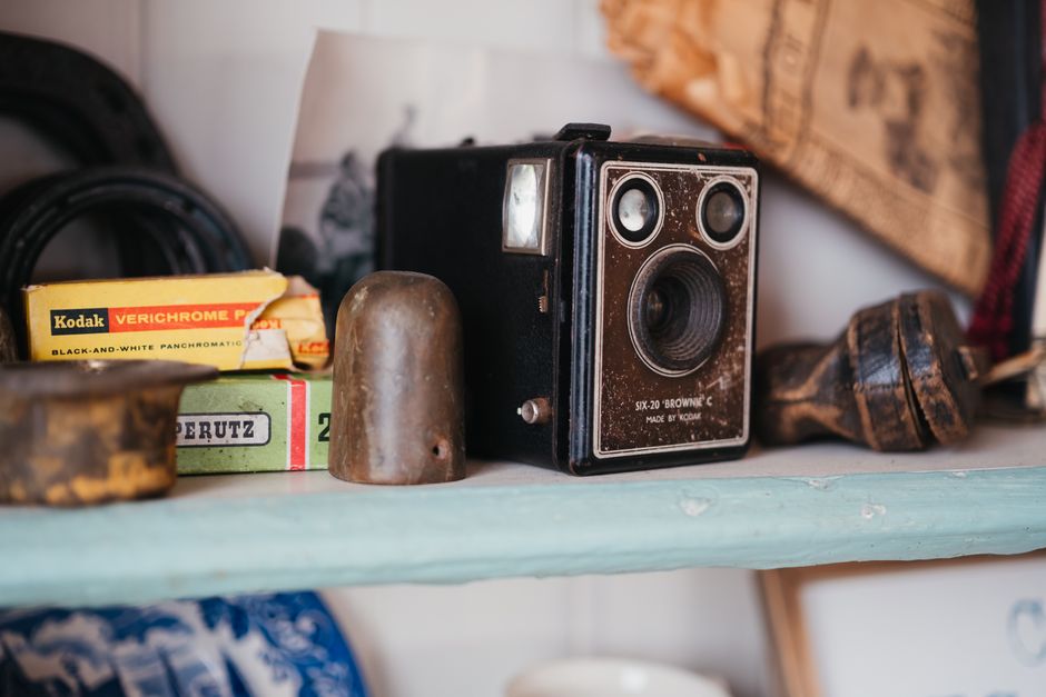 Explore nostalgic film photography with a classic Kodak Brownie camera displayed on a rustic shelf.