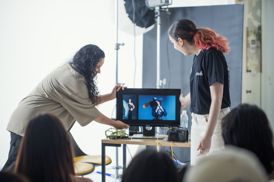 Photographers reviewing images on a monitor during a studio workshop.