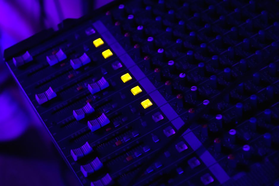 Detailed image of an illuminated audio mixing panel with glowing yellow lights, perfect for tech visuals.