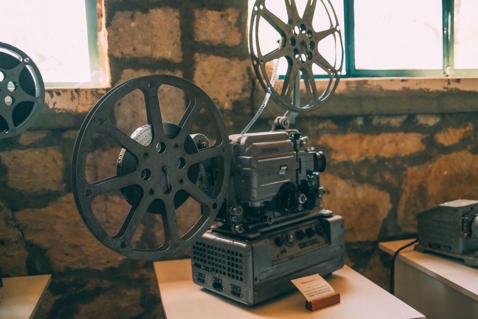 Classic vintage film projector displayed in a rustic indoor setting. Perfect for cinema enthusiasts.
