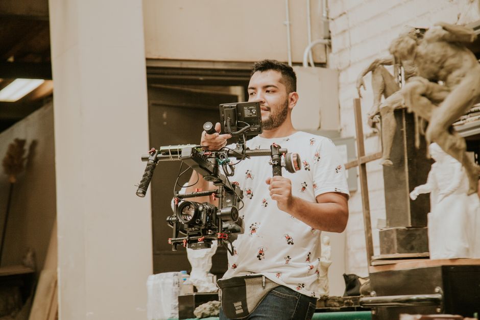 Videographer working with a professional stabilizing rig indoors, capturing behind-the-scenes moments.