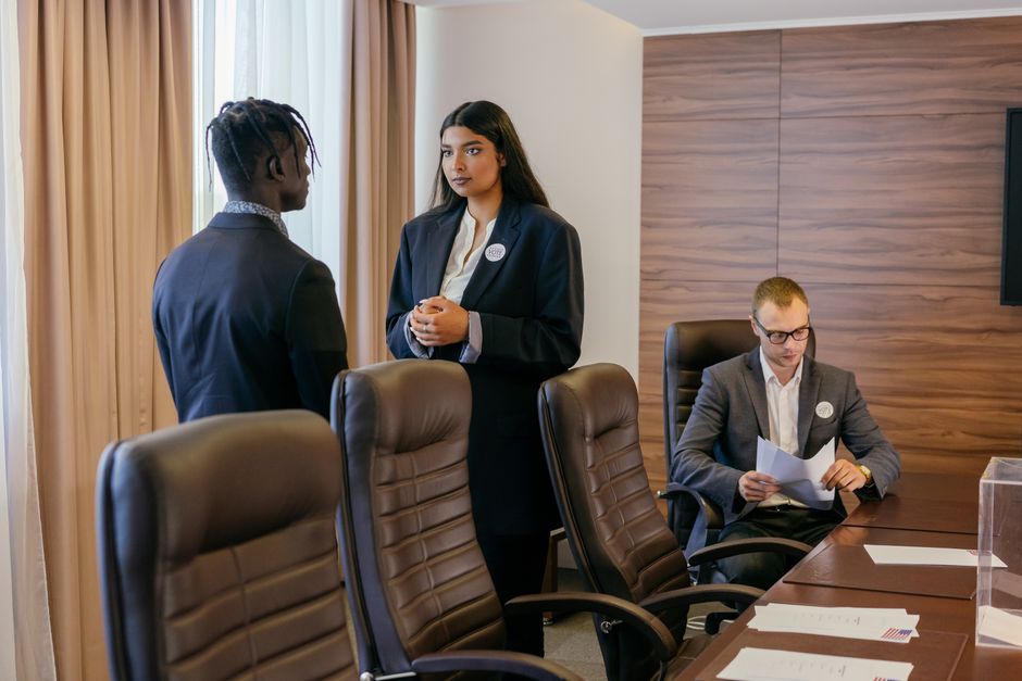 Three professionals discussing business strategy in a modern conference room.