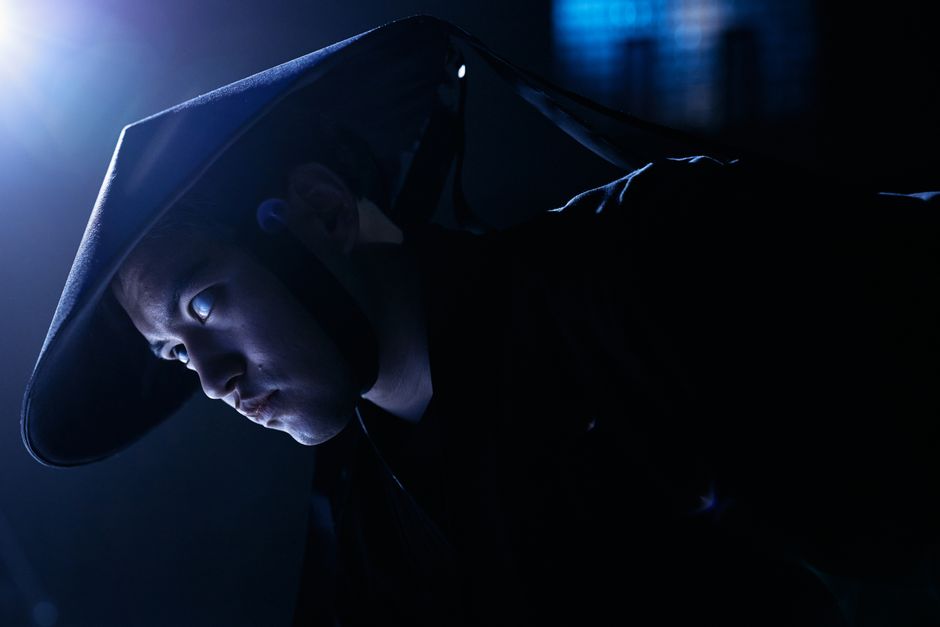 Dramatic low-key portrait of a cosplayer dressed as a game character, indoors, studio lighting.