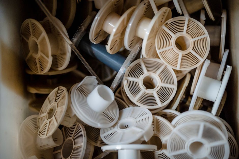 An abstract still life of multiple white plastic reels in a close-up view, offering a unique perspective.
