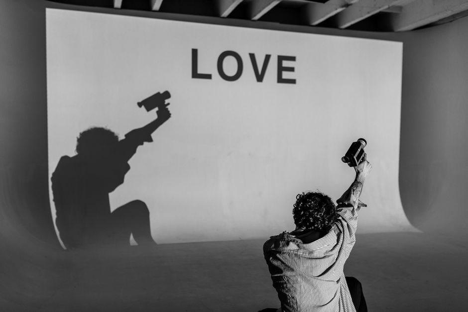 Artistic shadow projection with 'LOVE' text in a studio setting.