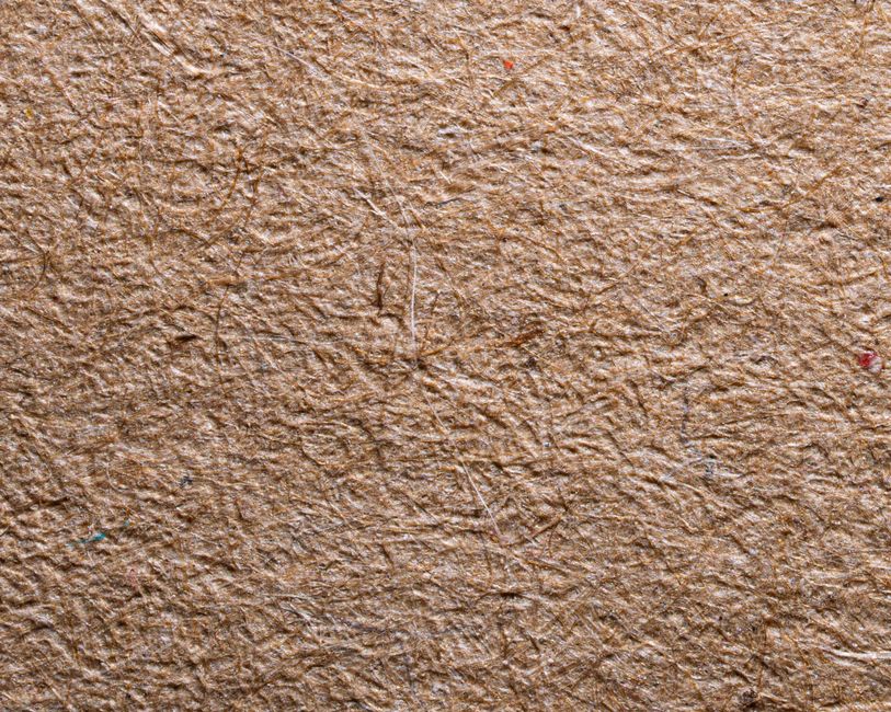 Close-up of brown recycled paper texture with visible fibers.