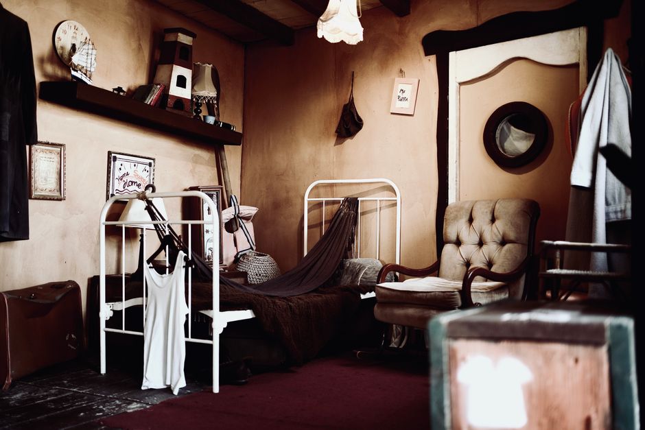 Warm vintage bedroom featuring an iron bed, armchair, and antique decor.
