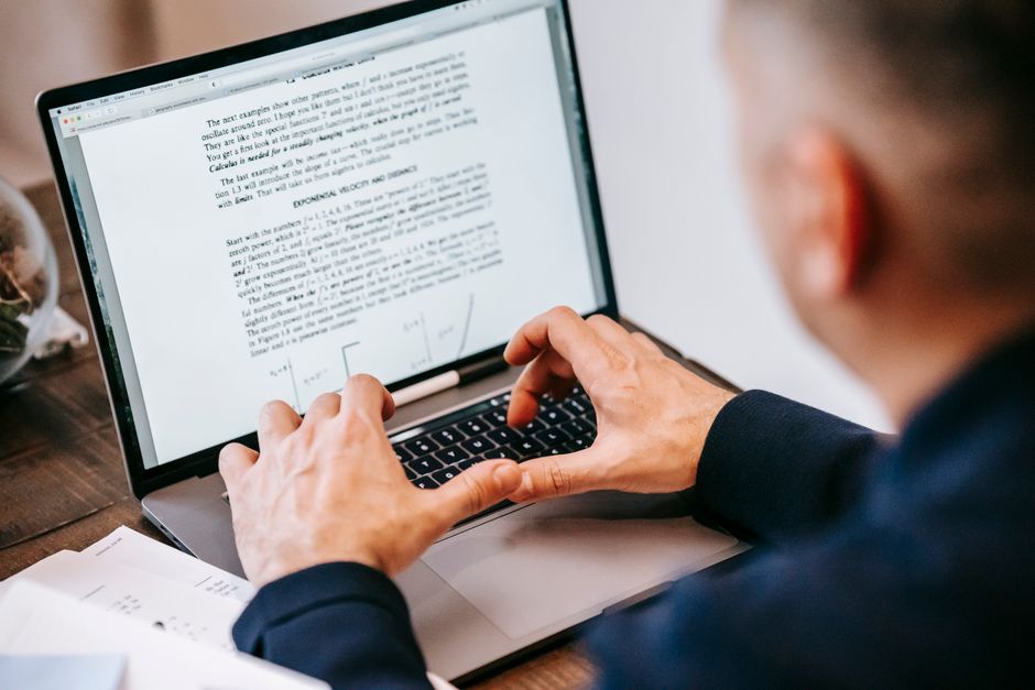 Man typing on laptop at home office, focused on work, illustrating remote work lifestyle.