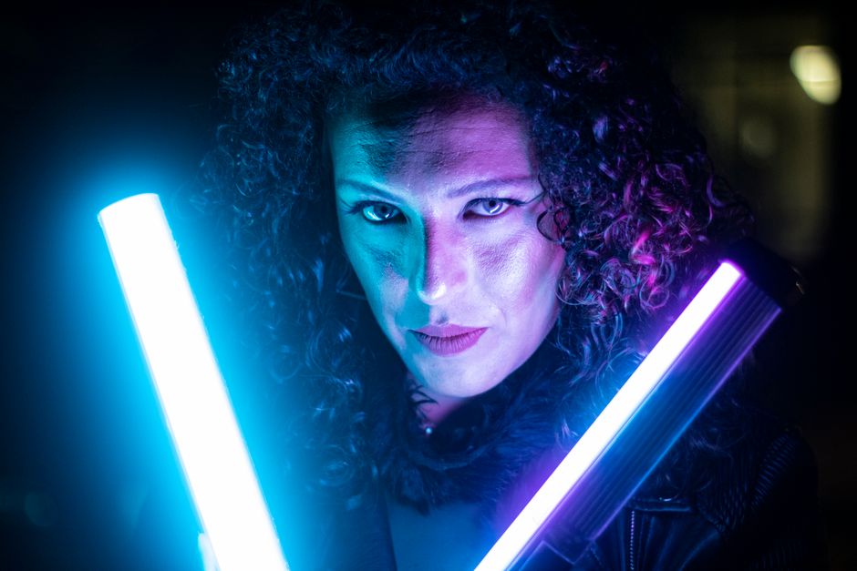 Close-up portrait of a person with neon blue and purple lights creating a dramatic atmosphere.