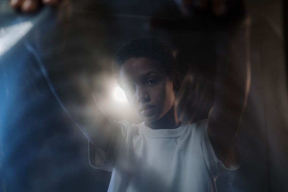 Artistic portrait of a young boy with soft lighting and a moody atmosphere, showcasing creativity.
