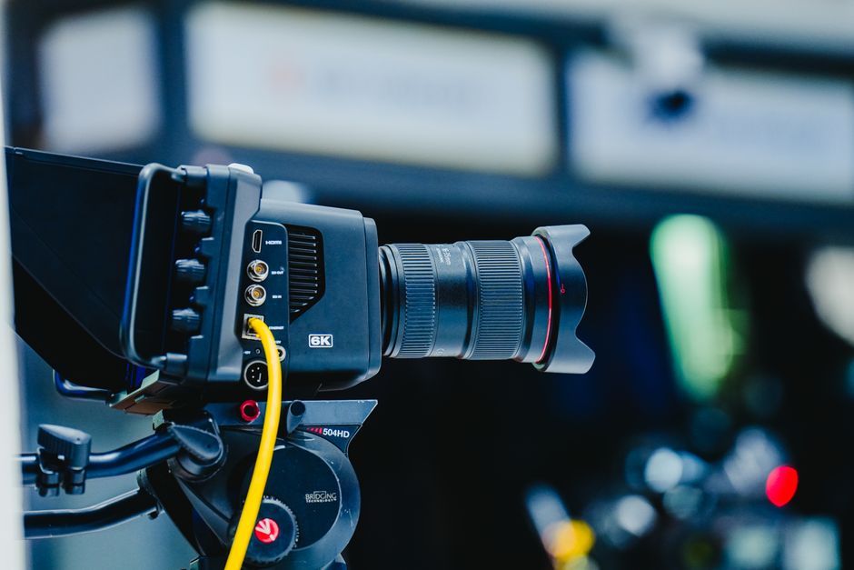 Close-up shot of a professional 6K video camera mounted on a tripod, ideal for filming and video production.