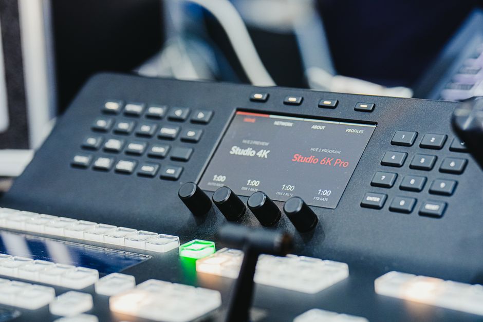 Closeup of a high-tech audio video control panel featuring digital displays and control buttons.