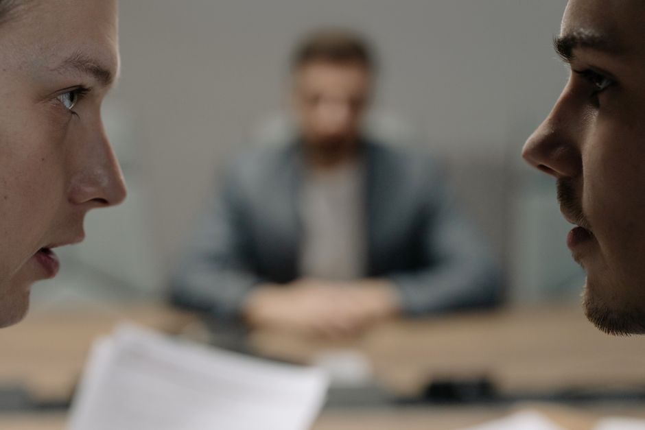 Close-up of two men in a serious discussion at a business meeting.