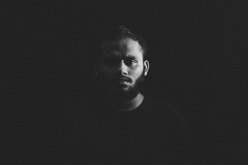A captivating, high-contrast portrait of a bearded man in black and white.