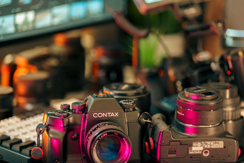 A detailed view of a Contax camera amidst a creative studio setup, showcasing film photography tools.