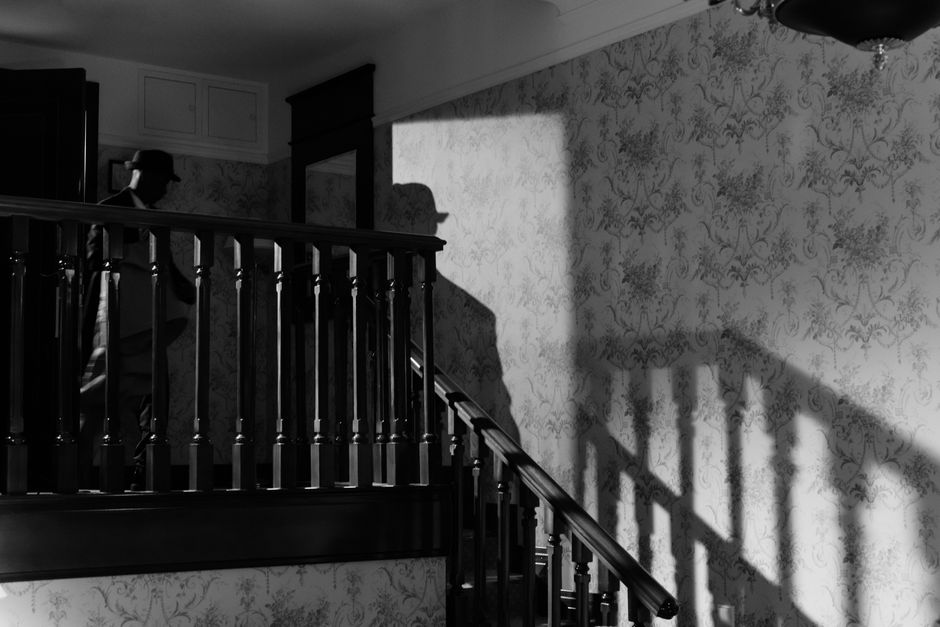 A mysterious noir scene with a detective's shadow on a vintage staircase.
