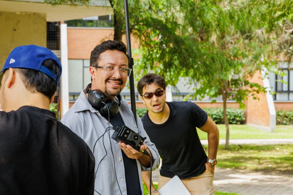 Film crew working on set outdoors with equipment, capturing candid moments.
