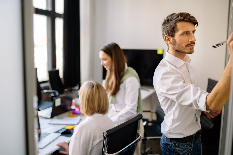 A focused team working together in a modern office setting, brainstorming and collaborating.