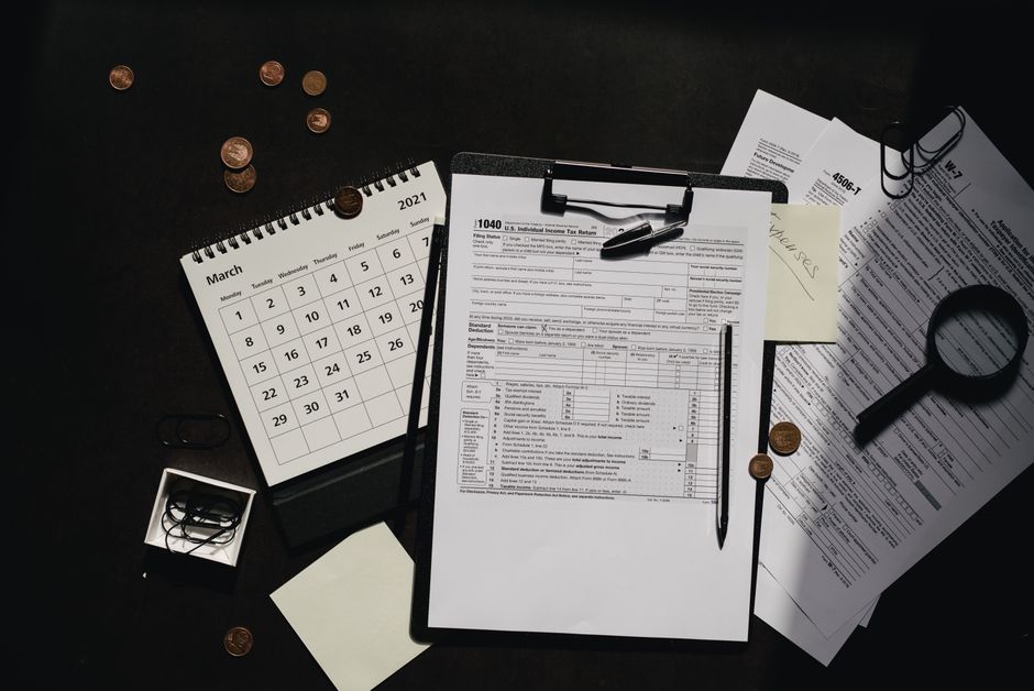 A neatly organized workspace featuring tax forms, calendar, magnifying glass, and office supplies for efficient tax preparation.