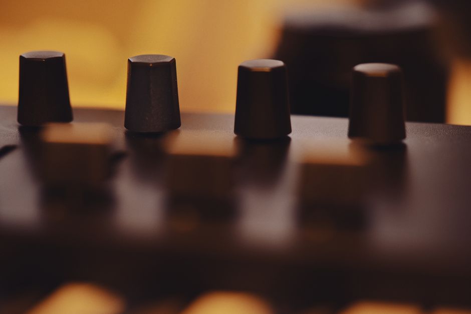 Artistic close-up of modern equipment knobs with warm light and soft focus for a cinematic feel.