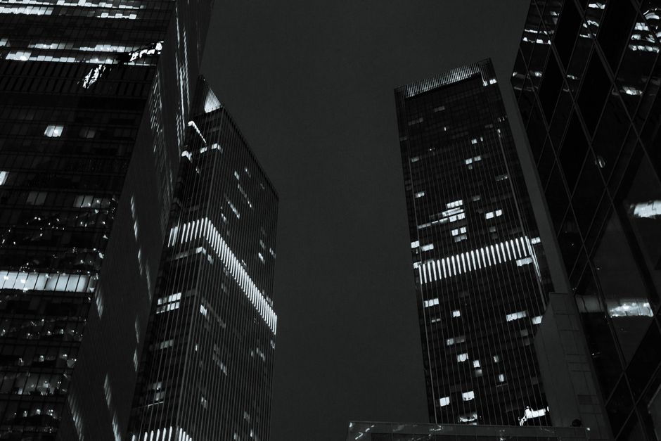 Low angle view of illuminated skyscrapers in Moscow at night, showcasing modern architecture.