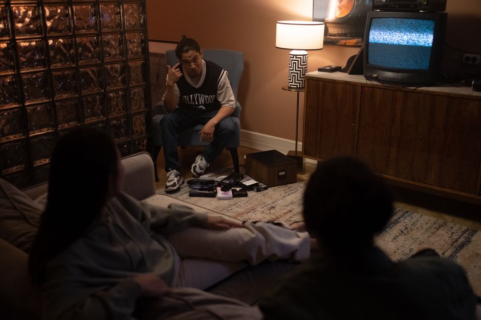 Three friends relax in a cozy room, watching TV together for a movie night.