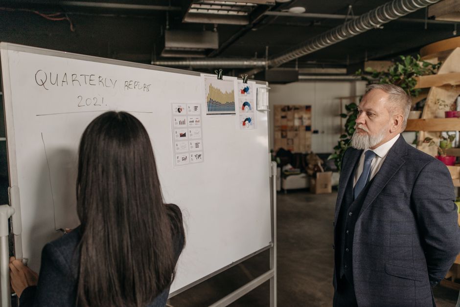 Business professionals discussing the 2021 quarterly report in a modern office setting.