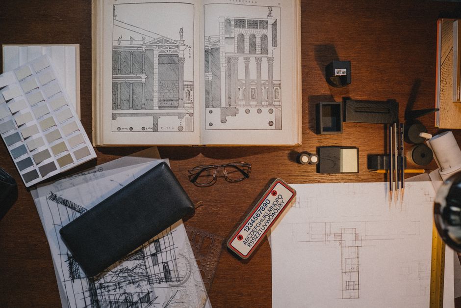 Flat lay of architectural tools and sketches on a desk, ideal for design and drafting concepts.