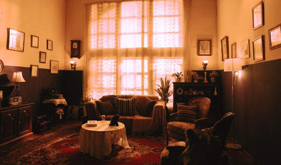 Cozy vintage living room with warm lighting and vintage decor, featuring a large window.
