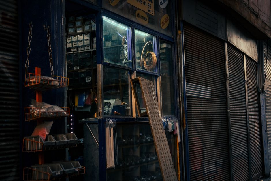 Dimly lit hardware store with tools and supplies in a vintage setting.