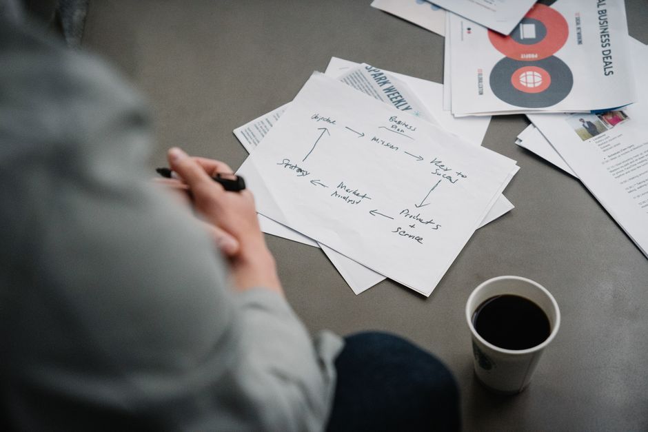 Cozy workspace with papers, plans, and a cup of coffee, perfect for brainstorming and planning sessions.