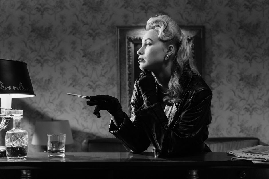 A stylish woman in vintage noir setting with cigarette holder, exuding mystery.