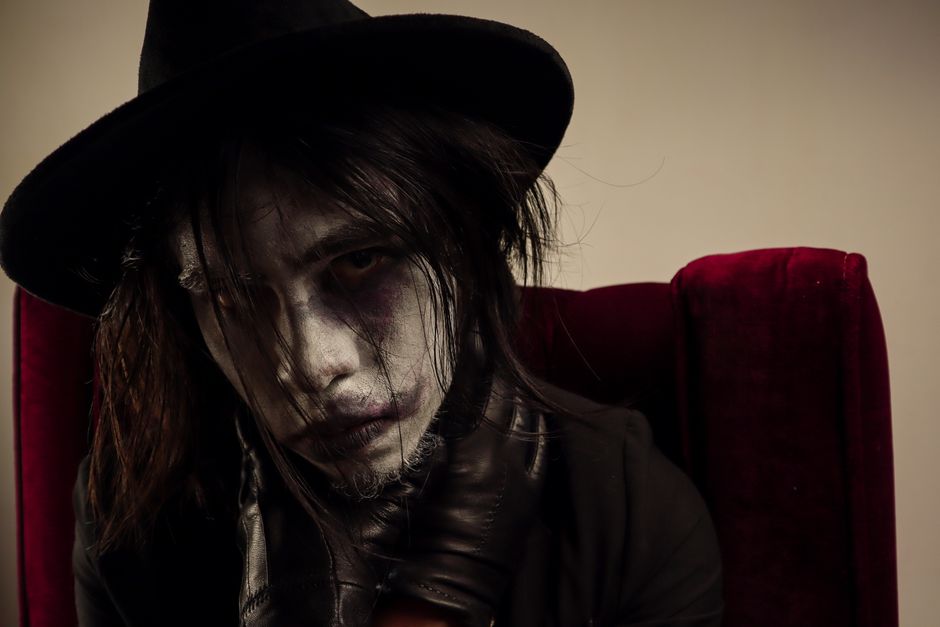 Intense gothic portrait with a focus on dramatic makeup and expressive features. Ideal for themes of mystery.