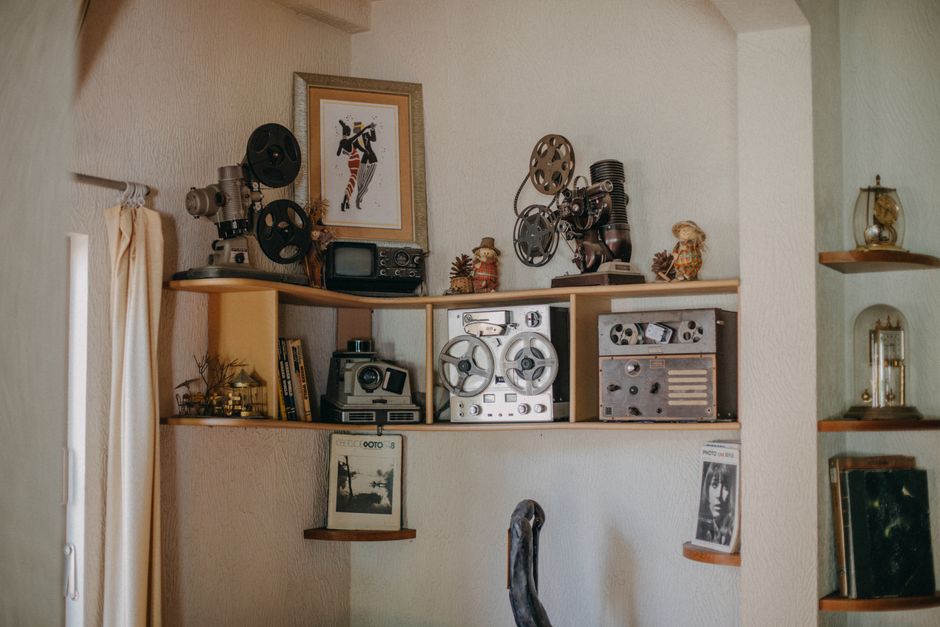 A cozy interior with vintage cameras and retro audio equipment on shelves.