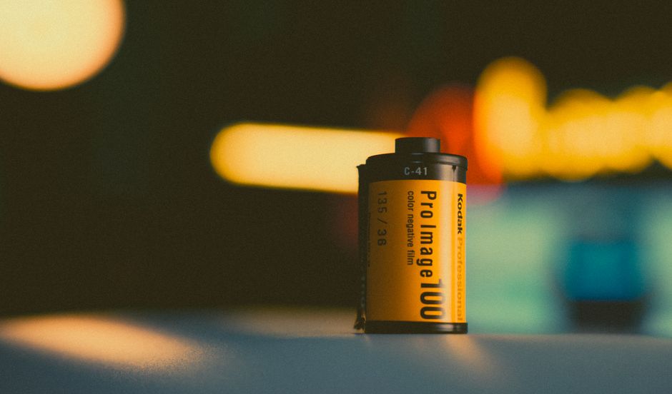 A Kodak Pro Image 100 film canister captured with a bokeh background for a nostalgic feel.