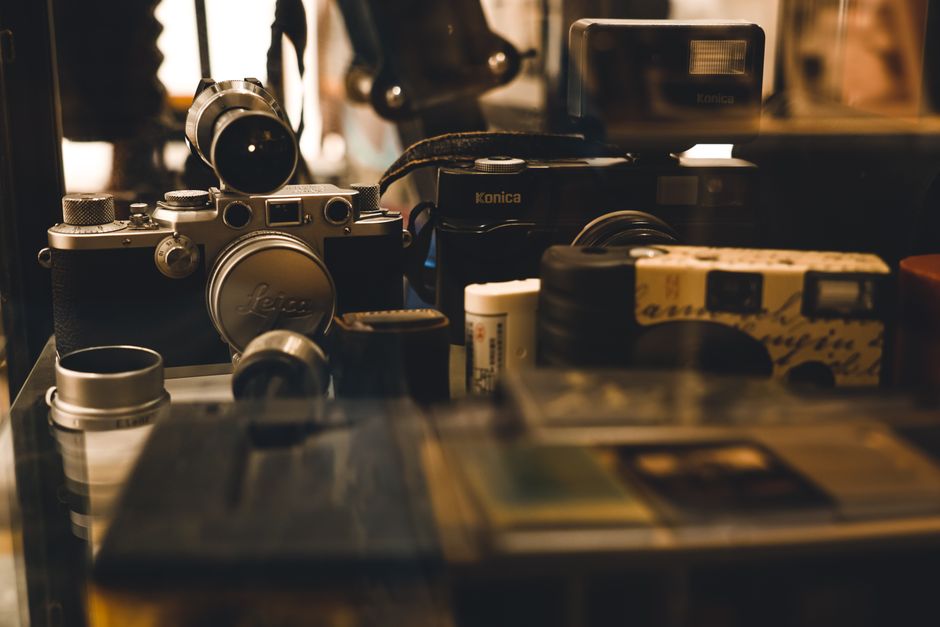 A collection of vintage cameras and photography equipment showcased in a display, highlighting retro aesthetics.