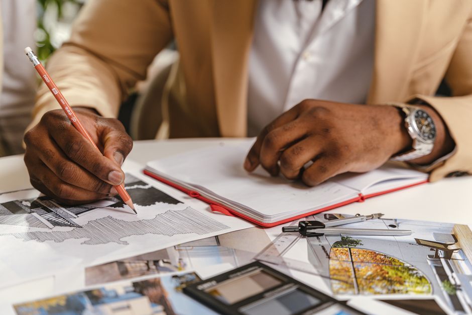 Architect sketching blueprints and planning in an office environment.