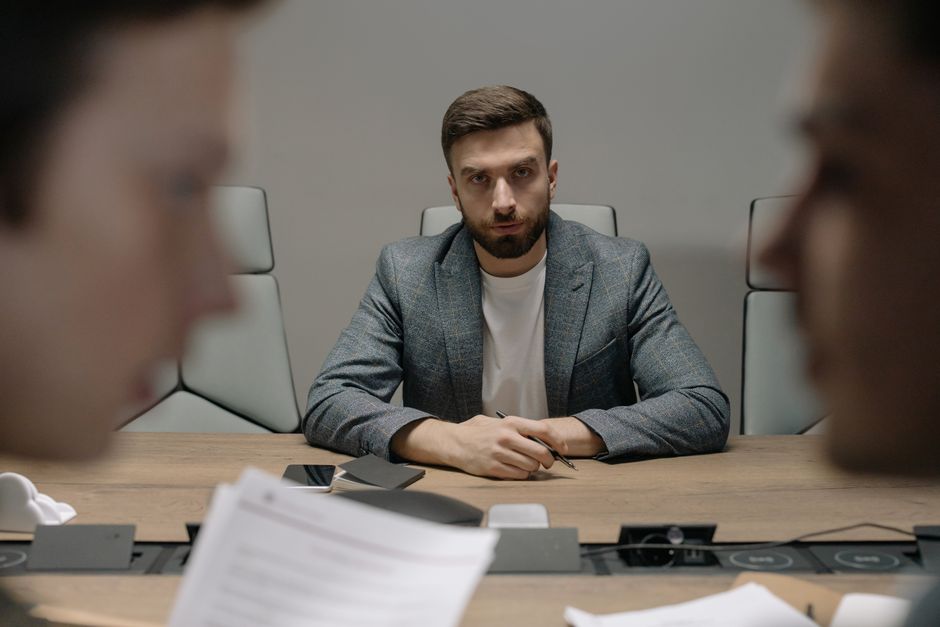 Serious businessmen engaged in a formal meeting around a conference table.